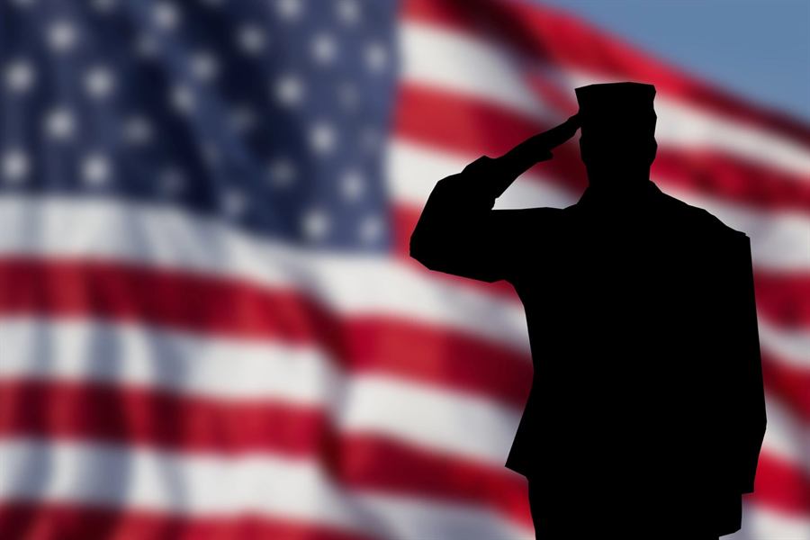 Silhouette of a saluting veteran against the American flag
